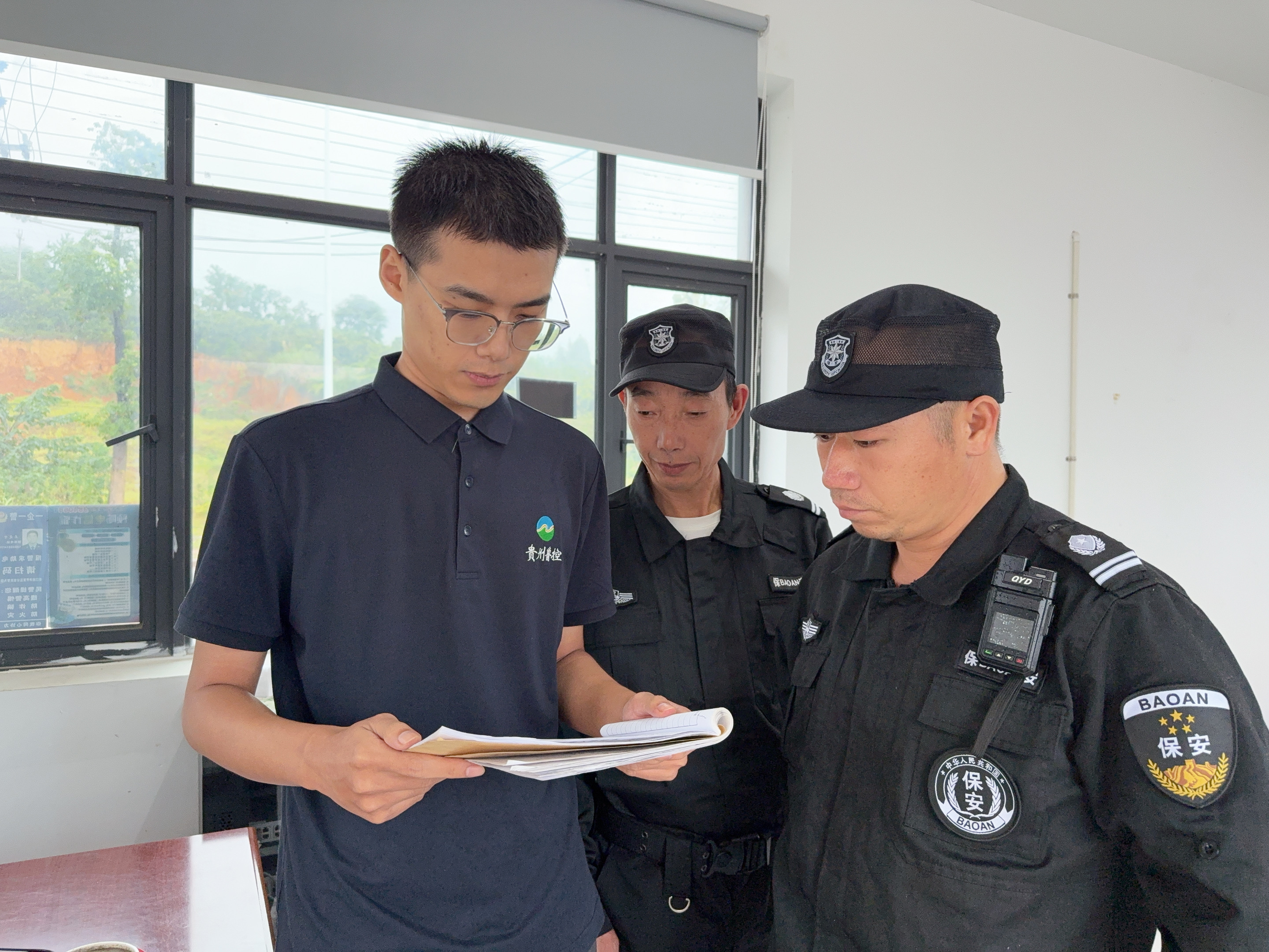 1760145610466.jpg 圖為李鵬程檢查進出車輛登記情況.jpg